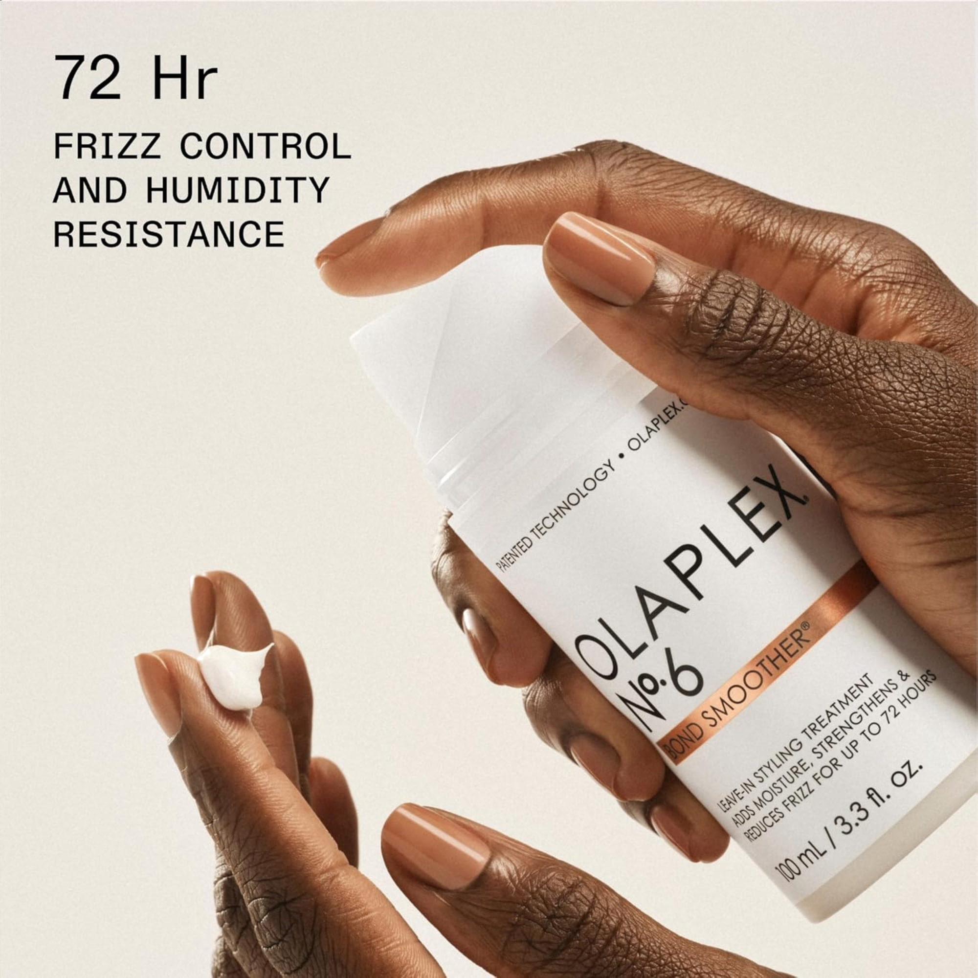 Olaplex hair treatment product with hands holding it on a beige background